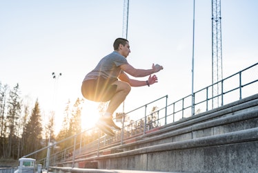 训练有素的男子在日落时分在体育场的楼梯上锻炼