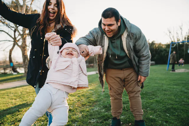 Family with one little daughter at the park together. Caucasian ethnicity. They are having fun toget...