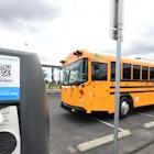 A new EV school bus from an all-electric fleet is parked beside charging stations at South El Monte ...