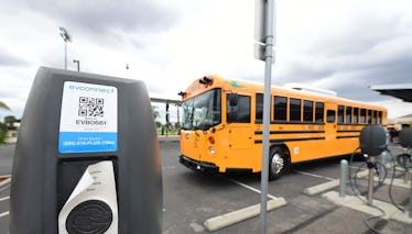 A new EV school bus from an all-electric fleet is parked beside charging stations at South El Monte ...