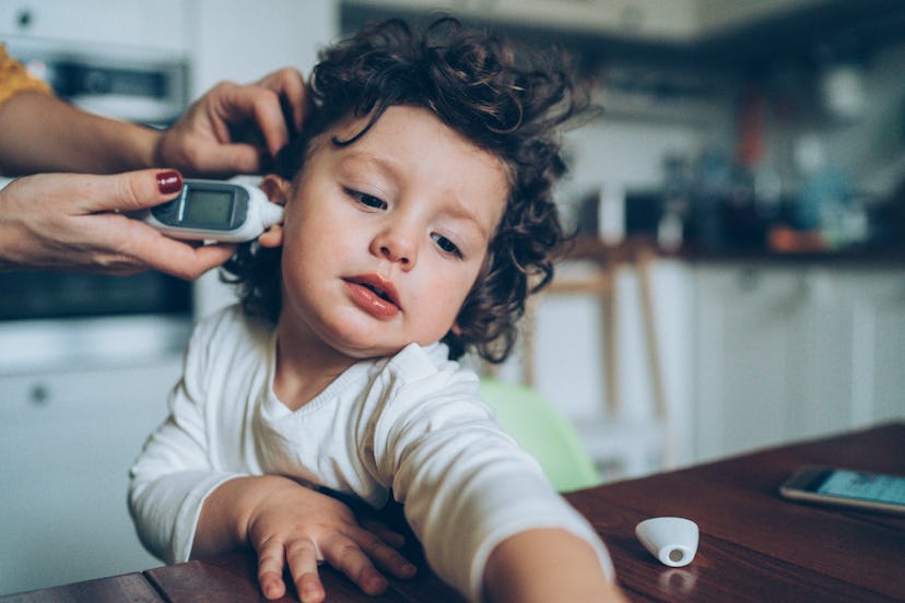 Mother with ear thermometer checking temperature