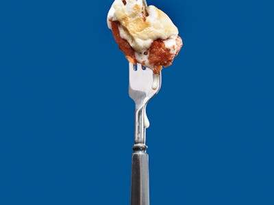 Candied Yam dripping on silver black fork over blue background