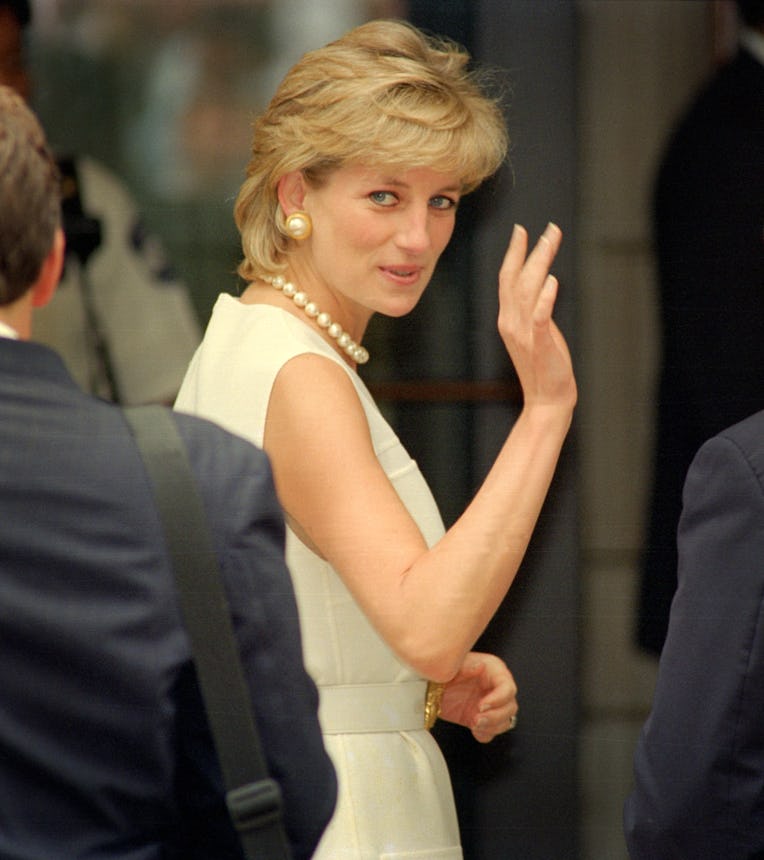 View of Diana, Princess of Wales (1961 - 1998), a bouquet in one hand, as she shakes hands with an o...
