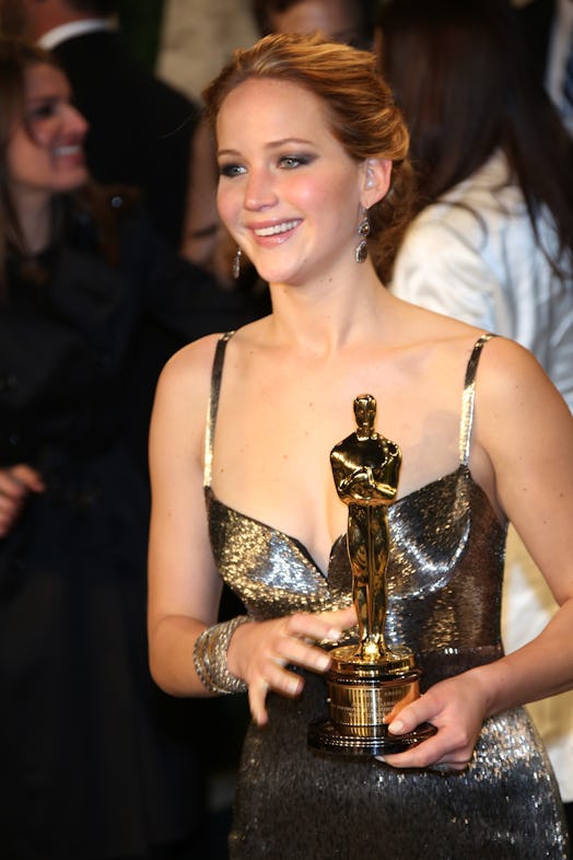 Jennifer Lawrence at the Vanity Fair Oscar Party at Sunset Tower in West Hollywood holding an Oscar.