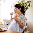 Young pregnant woman alone in her kitchen enjoying a breakfast. A new study suggests that even the s...