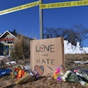 Bouquets of flowers and a sign reading "Love Over Hate" are left near Club Q, an LGBTQ nightclub in ...