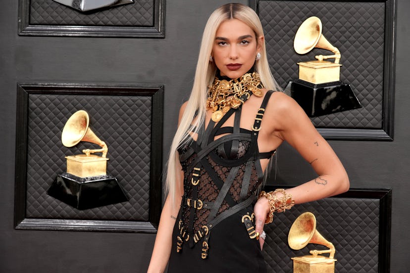 Dua Lipa attended the 64th Annual GRAMMY Awards in April 2022 with straight blonde hair and dark red...