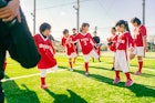 女子儿童足球队的队员们正在开始训练前热身。