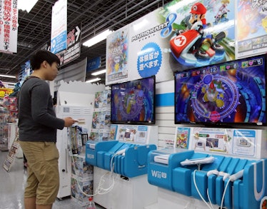 A customer plays a video game of Nintendo's Wii U at an electric shop in Tokyo on May 7, 2015. Japan's...