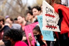 人们在美国Washi教育部外举行的取消学生债务集会上举着标语。