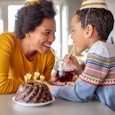 Photo of mother and her son at home with birthday cake celebrating