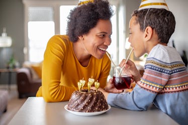 Photo of mother and her son at home with birthday cake celebrating