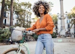 Young African American woman exploring Barcelona by a bike and enjoying her journey.
