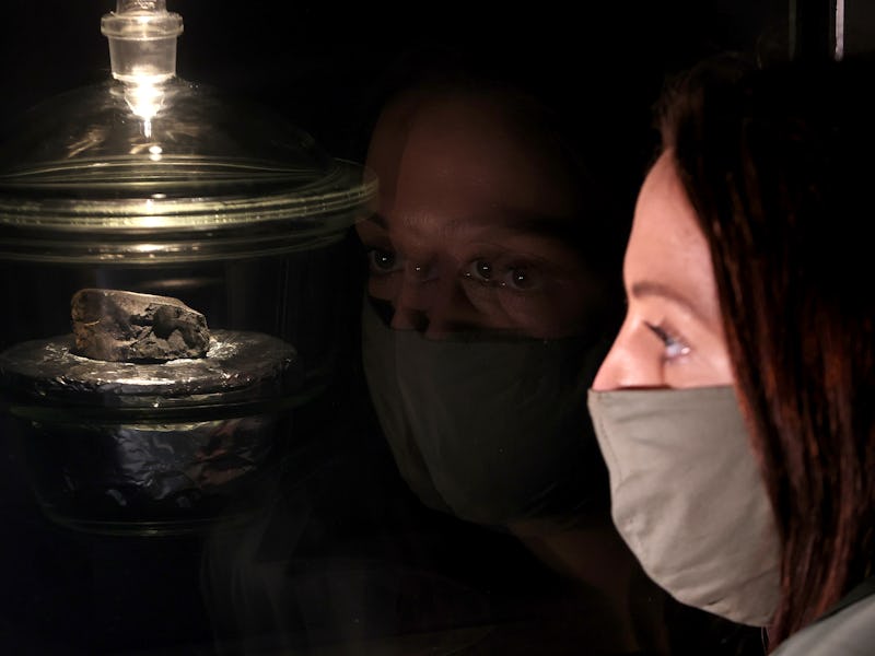 LONDON, ENGLAND - MAY 13: A lady takes a closer look at the Winchcombe meteorite that has gone on di...