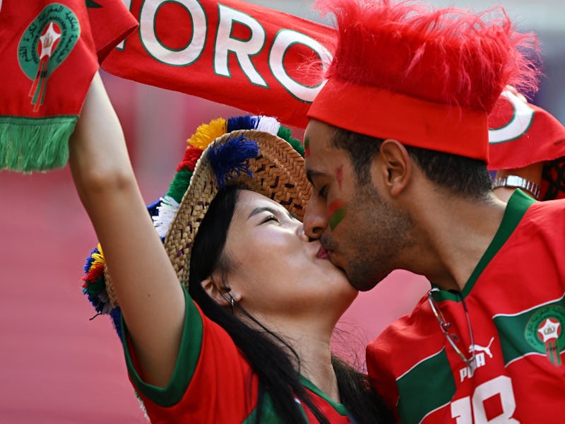 TOPSHOT - Fans of Morocco kiss on the stands ahead of the Qatar 2022 World Cup Group F football matc...