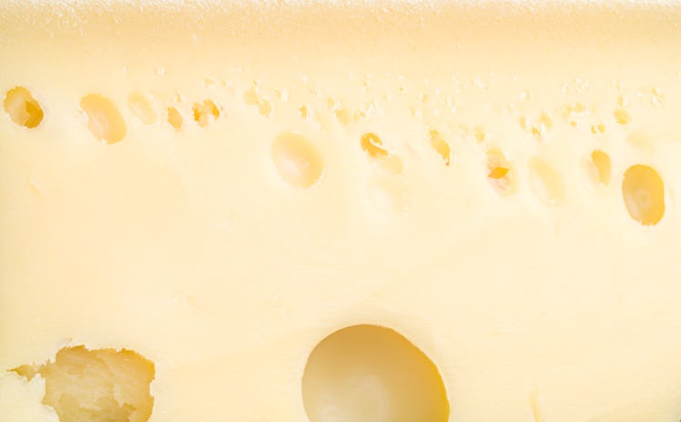 Extreme close up full frame yellow Emmental cheese with holes