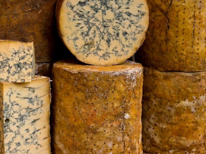 A stack of blue cheese on a market stall.