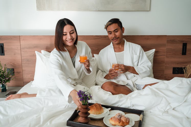 A couple enjoying hotel breakfast, a way to save money, is one of the 2023 travel trends and predict...