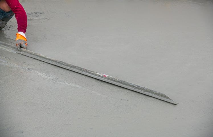 Workers pour concrete on the road in the factory.