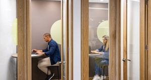Latin American business people working in private cubicles at a coworking office