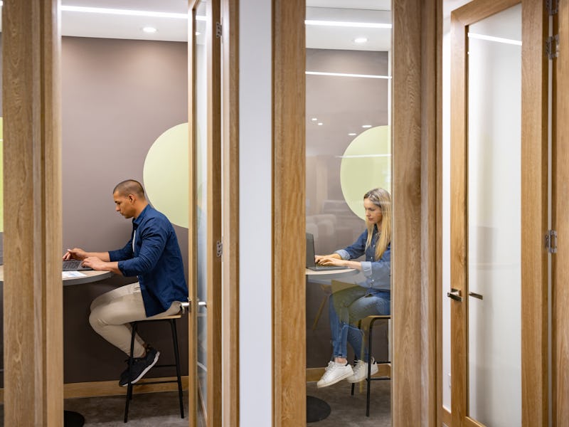 Latin American business people working in private cubicles at a coworking office
