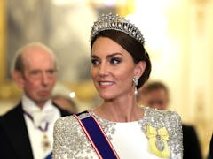 Kate Middleton, wearing the Lover's Knot tiara and Princess Diana's earrings, attends a state banque...