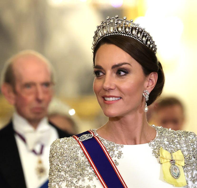 Kate Middleton, wearing the Lover's Knot tiara and Princess Diana's earrings, attends a state banque...