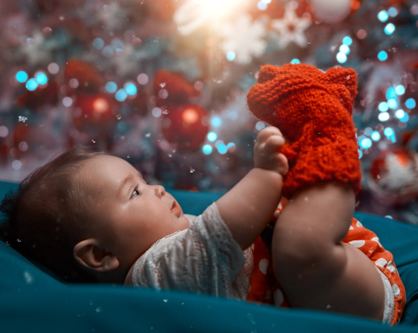 side view of baby girl in Christmas time playing and lying on back.holiday concept.