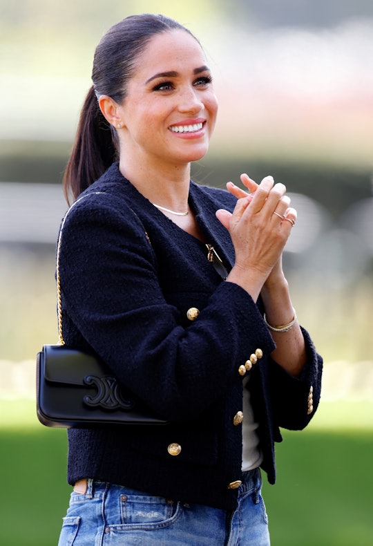 Meghan, Duchess of Sussex wearing a navy blazer and jeans. Meghan Markle spent Thanksgiving 2022 fee...