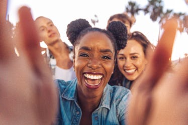 friends take a selfie at the beach as they discuss how the december 2022 full cold moon will affect ...