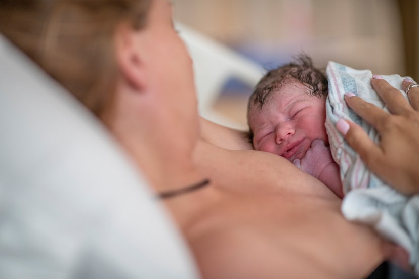 A Mother holds her newborn baby in an article about the ring of fire during childbirth