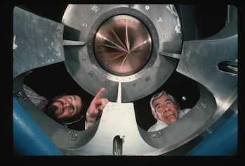 Dennis Atkinson (left) and Robert Wade look down at the mirror of the REFLAXICON high-energy laser. ...