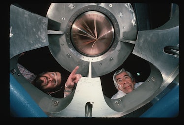 Dennis Atkinson (left) and Robert Wade look down at the mirror of the REFLAXICON high-energy laser. ...