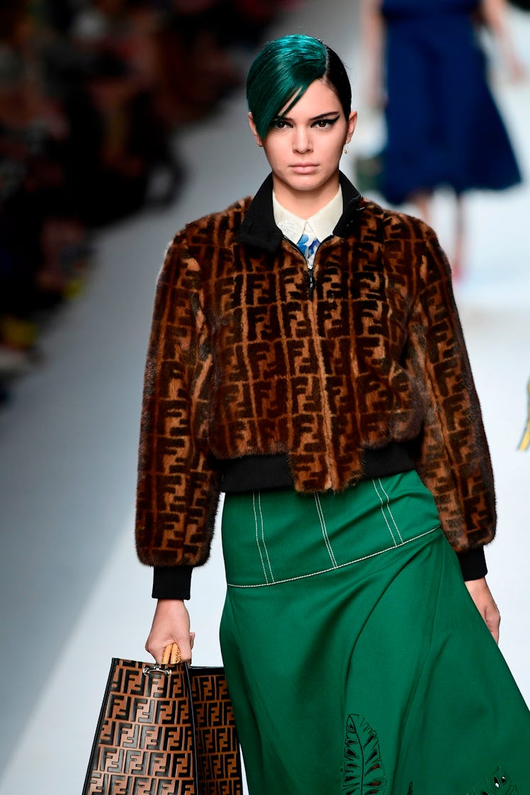 Kendall Jenner, with green hair, presents a creation for fashion house Fendi during the Women's Spri...