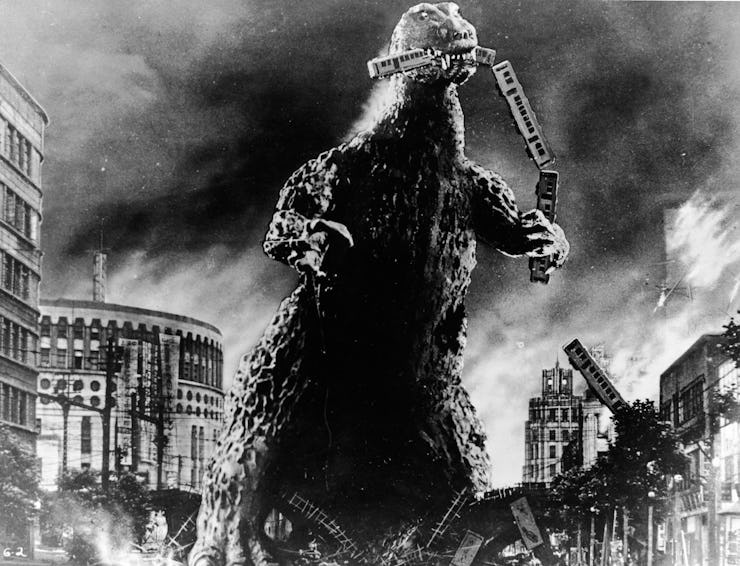 Radioactive monster Godzilla stomps through a city and eats a commuter train in a scene from 'Godzil...