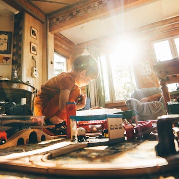 Boy playing with train set at home.