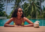 A woman in a pool is traveling based on the 2023 travel trends and predictions, according to experts...