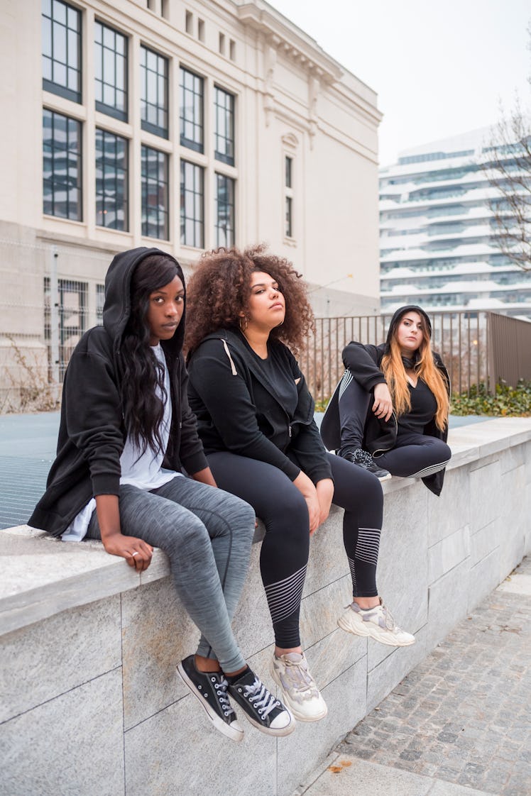 three friends relax outside and pose for a photo as they discuss how the new moon in sagittarius wil...