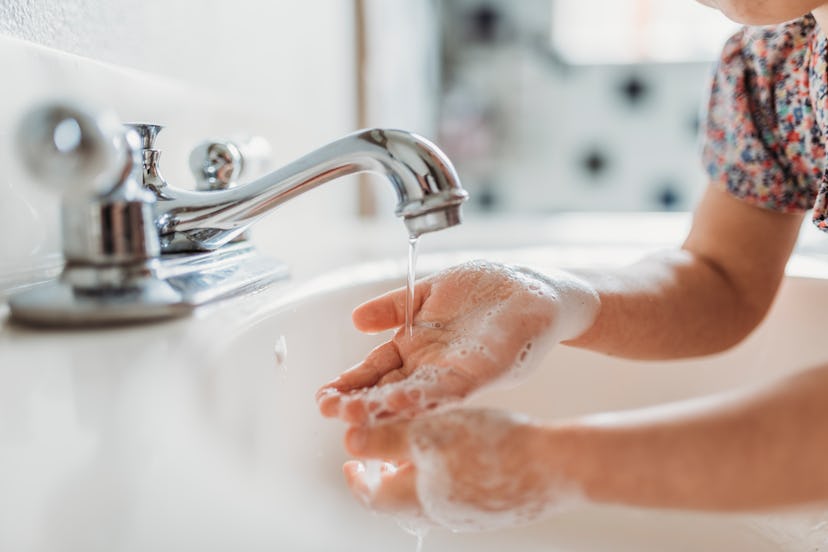 little kid washing hands in an article about day care sickness and how to keep your kid healthy