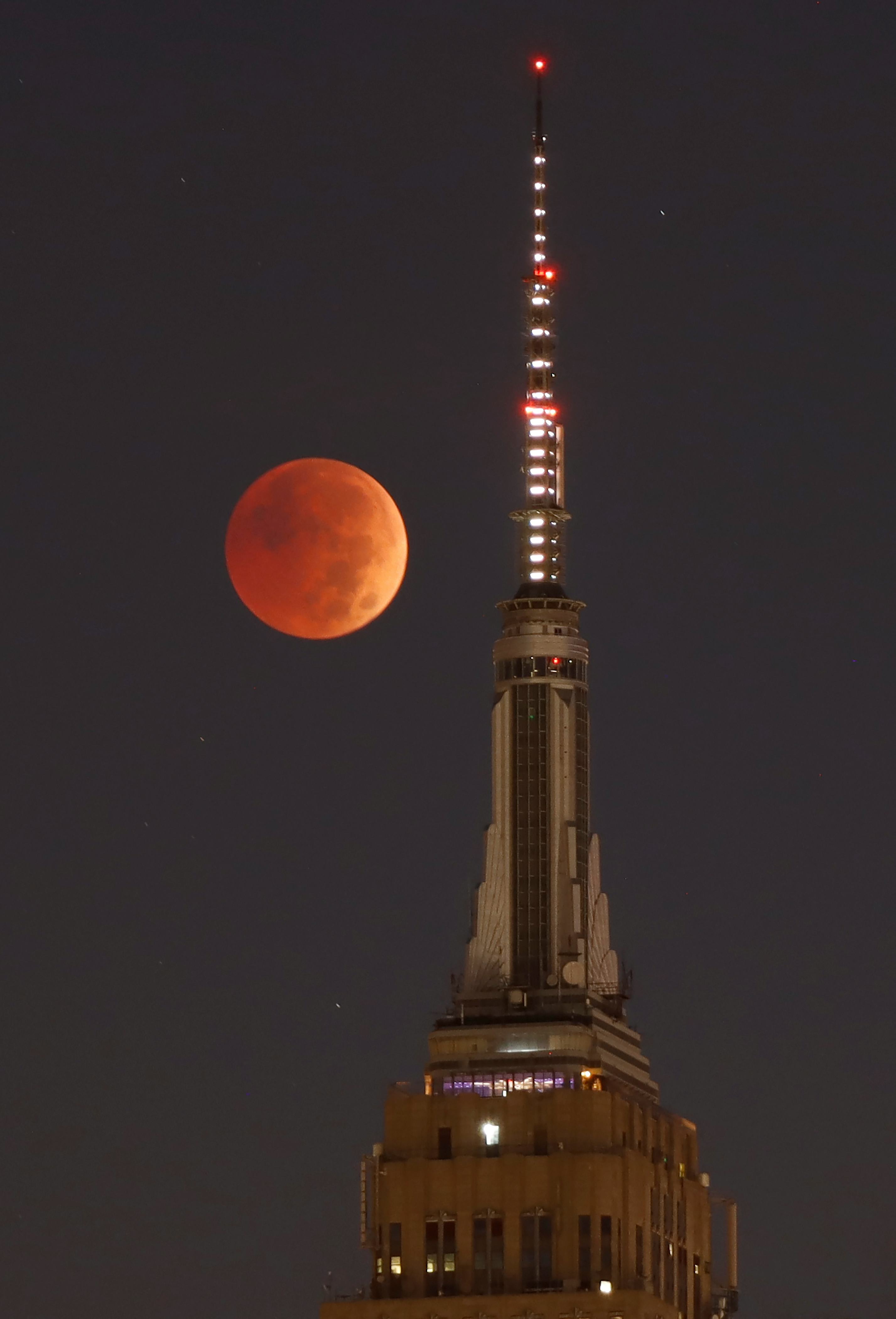 NEW YORK, NY - NOVEMBER 8: The blood-red full Beaver Moon passes behind the Empire State Building du...