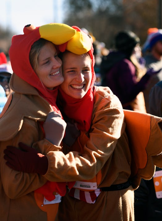 Two runners wearing turkey costumes at a turkey trot race may post a turkey trot Instagram caption a...