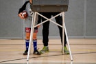 一个小男孩在格林威治高中等待他的父亲投票。