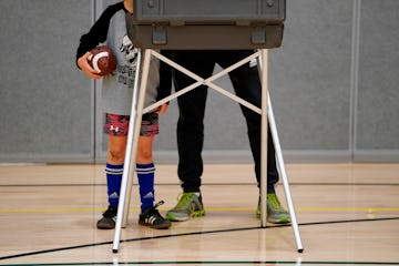 TOPSHOT - A young boy waits for his father to cast his ballot  at Greenwich High School in Greenwich...