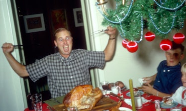 A father takes particular glee in carving up the Thanksgiving turkey.