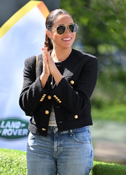 Meghan Markle wearing a black jacket and jeans.