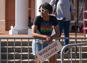 A woman stands against a fence before Sen. Raphael Warnock (D) speaks at a campaign event at Atlanta...