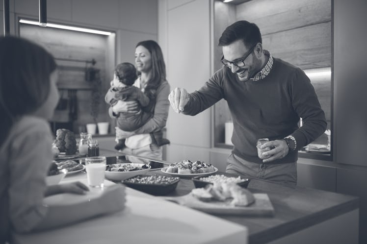 Happy father finishing snacks for his family in the kitchen.