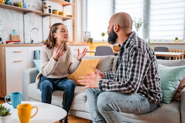 Young couple with relationship problems arguing on the sofa in the living room.