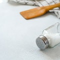 A new clean Wooden spatula, a kitchen towel and a salt shaker on the dining table. The concept of co...
