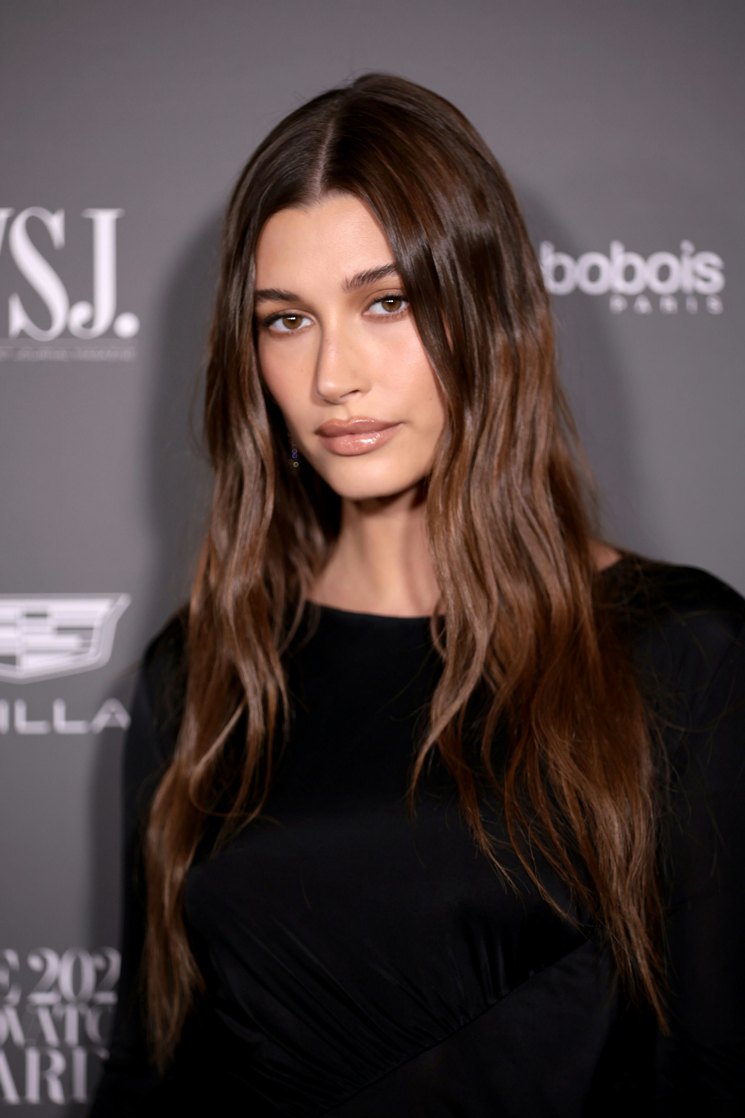 Hailey Bieber with illuminated brunette hair.